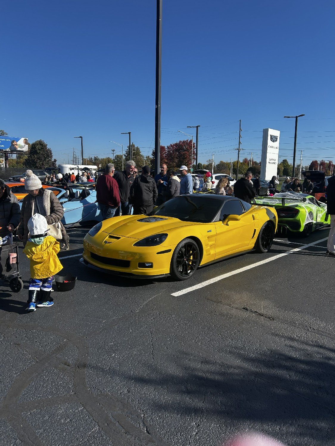 A yellow Corvette and a young trick-or-treater at Cars & Candy